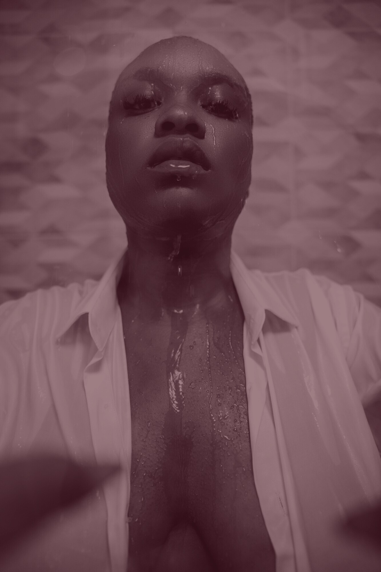 ADĀĀH en gros plan, le visage et le buste ruisselants d'eau, une chemise blanche ouverte, dans une lumière chaude.