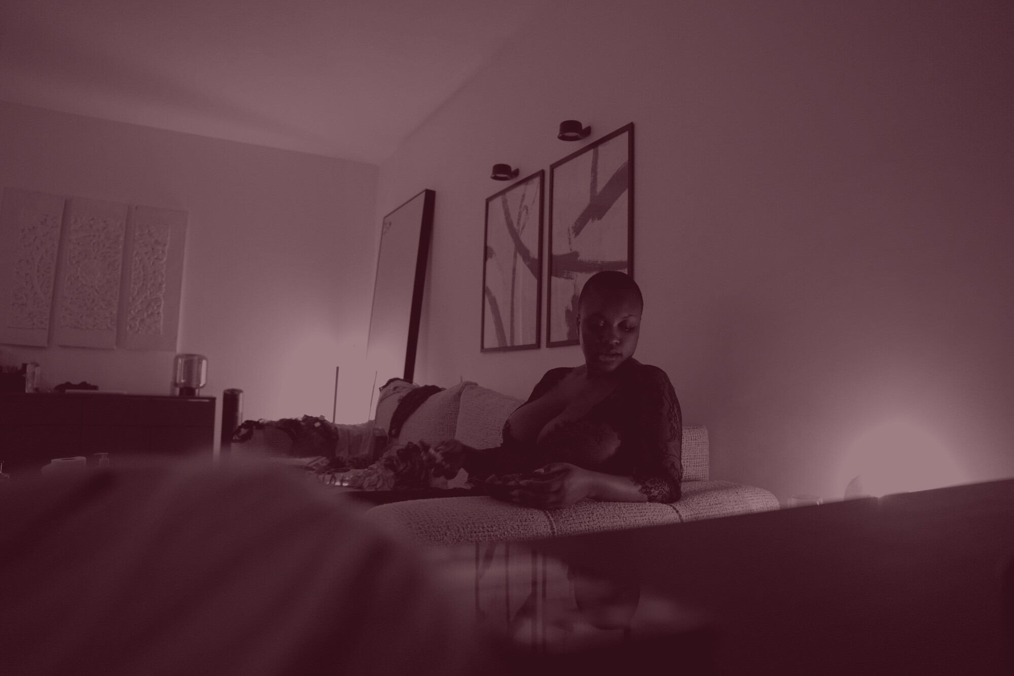 Une chambre baignée de lumière bleue, ADĀĀH allongée sur le lit, vue en plan large.